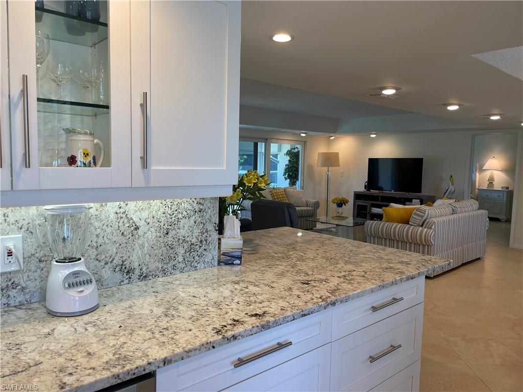 261 Quails Nest Road, Unit 6 Naples, FL 34112 - Photo 10 of 32 a view of living room with granite countertop furniture and flat screen tv