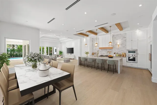 a kitchen with stainless steel appliances kitchen island dining table and chairs