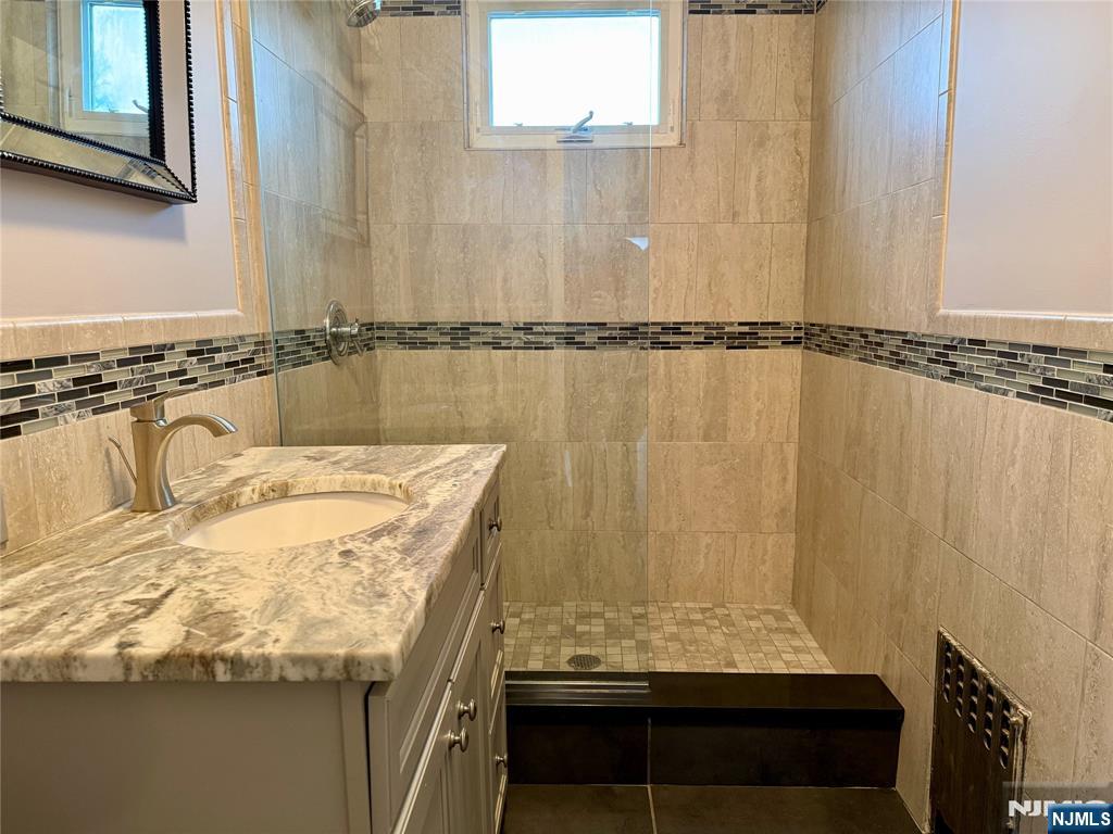 59 Laurel Avenue, Unit RIGHT SIDE Kearny, NJ 07032 - Photo 6 of 16 a bathroom with a granite countertop sink and a mirror