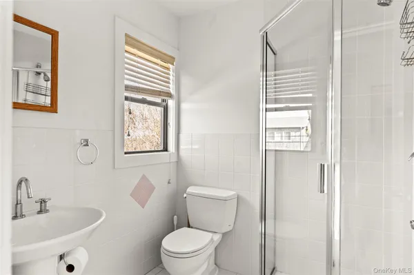 a bathroom with a sink a toilet and a window
