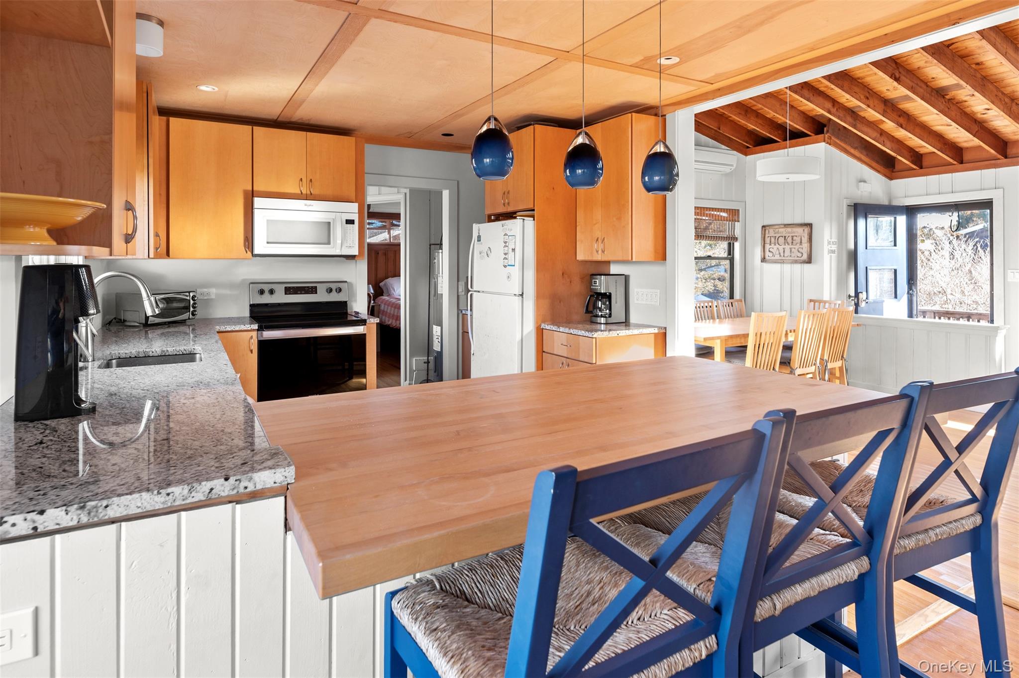 35 Sloop Walk Ocean Beach, NY 11770 - Photo 4 of 21 a kitchen with stainless steel appliances kitchen island granite countertop a table chairs in it and wooden floors