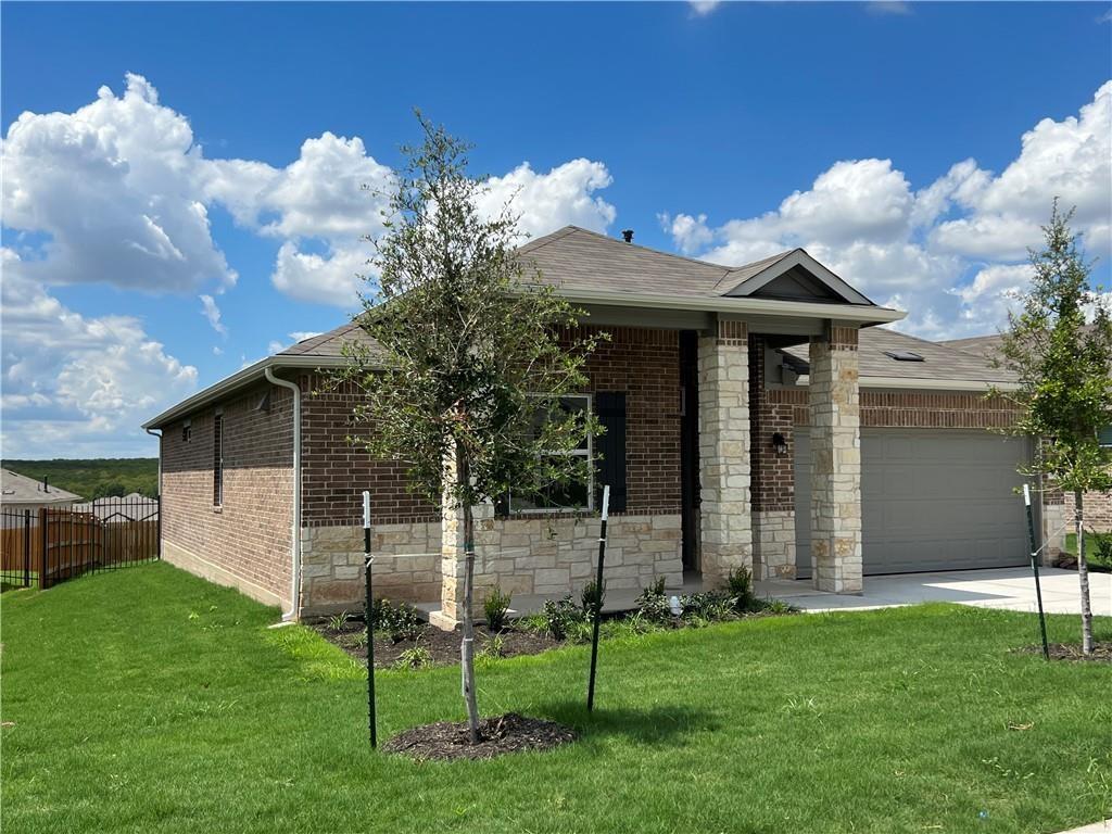 10600 Defender Trail Austin, TX 78754 - Photo 1 of 21 View of front facade with a garage, stone siding, driveway, and brick siding