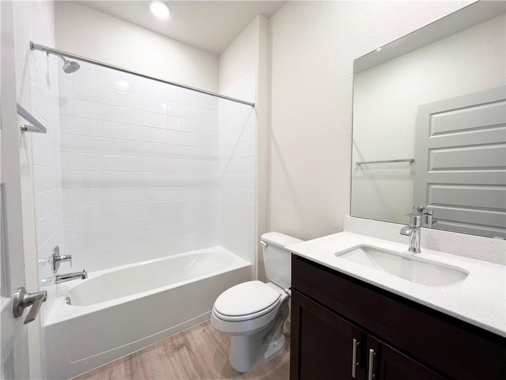 10600 Defender Trail Austin, TX 78754 - Photo 13 of 21 Full bath featuring vanity, light wood-type flooring, and bathtub / shower combination