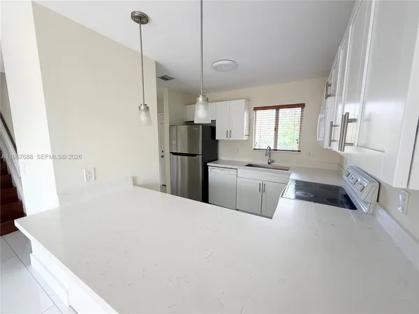 a kitchen with refrigerator and window