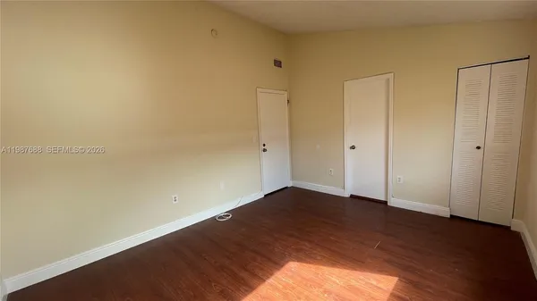 a view of an empty room with wooden floor