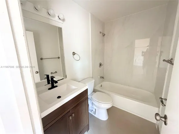 a bathroom with a sink mirror toilet and bathtub