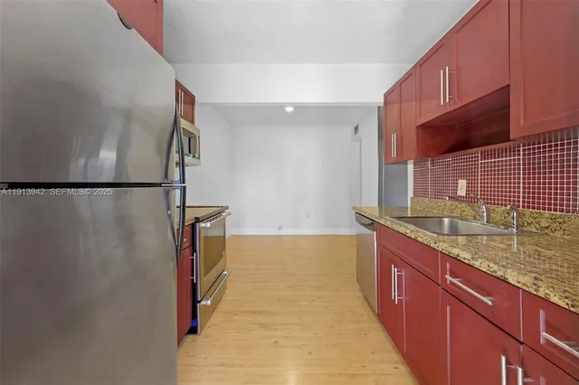 a kitchen with stainless steel appliances granite countertop a sink and a refrigerator