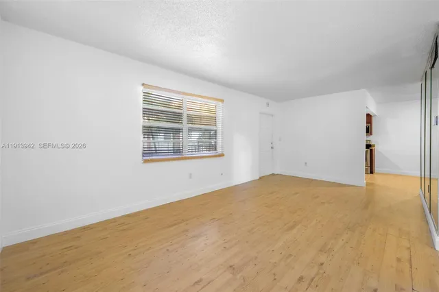 a view of empty room with wooden floor