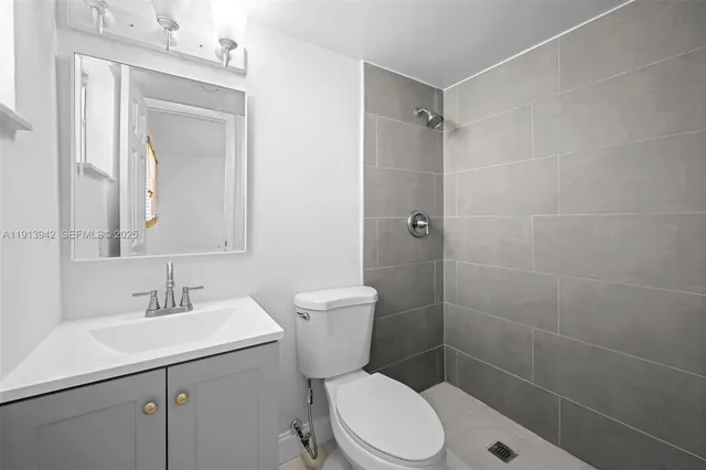 a bathroom with a toilet sink shower and mirror