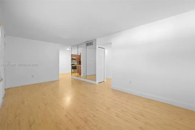a view of empty room with wooden floor
