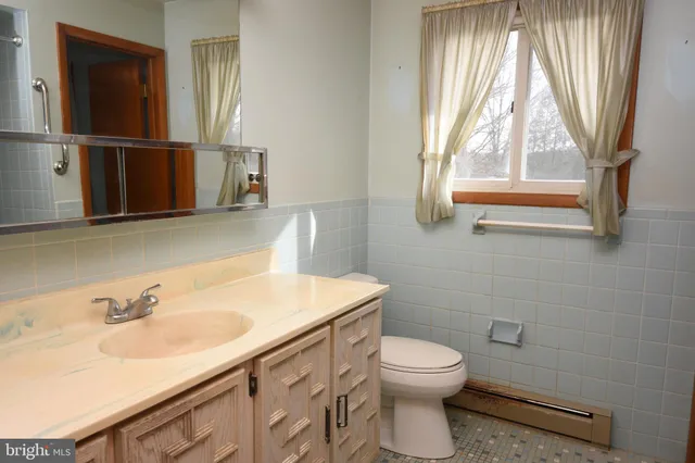 a bathroom with a sink toilet a mirror and window