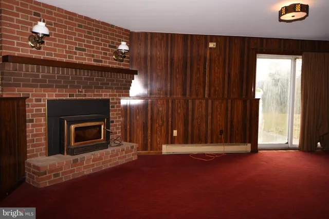 an empty room with windows and fireplace