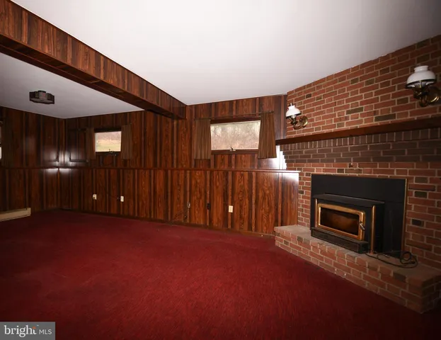 a view of a livingroom with fireplace and window