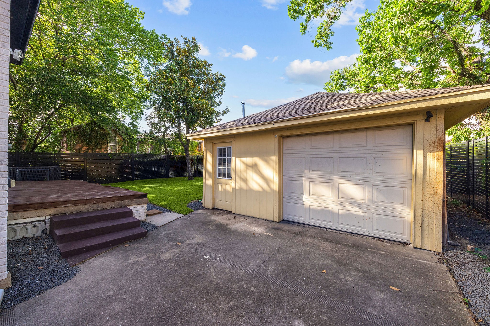 2613 Wichita Street Houston, TX 77004 - Photo 22 of 25 Private backyard with mature trees, green space, a large deck for outdoor entertaining, and a detached garage.