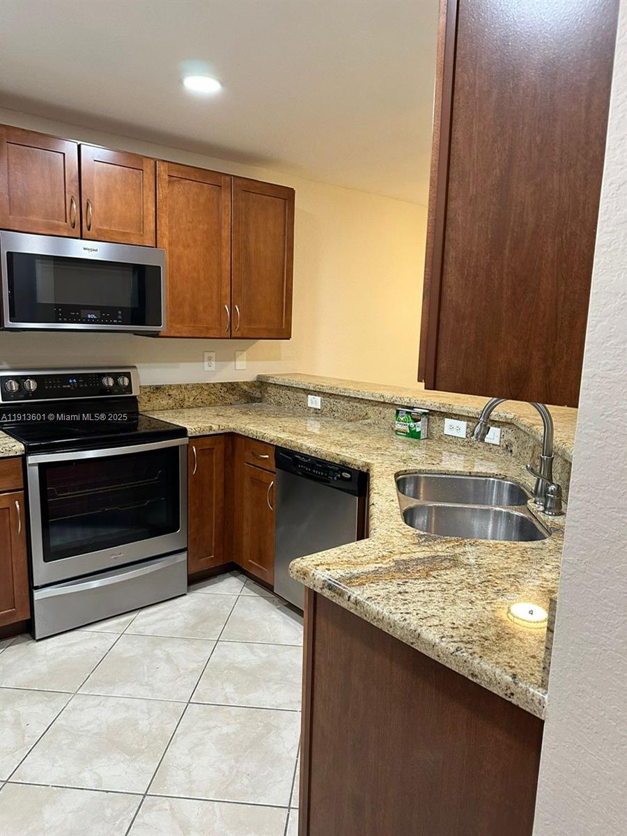 9113 Chambers Street Tamarac, FL 33321 - Photo 1 of 13 a kitchen with stainless steel appliances granite countertop a stove a sink and a microwave