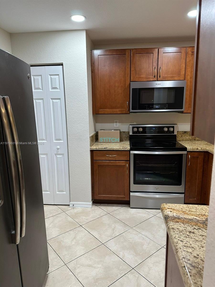 9113 Chambers Street Tamarac, FL 33321 - Photo 5 of 13 a kitchen with stainless steel appliances a stove a microwave and a refrigerator