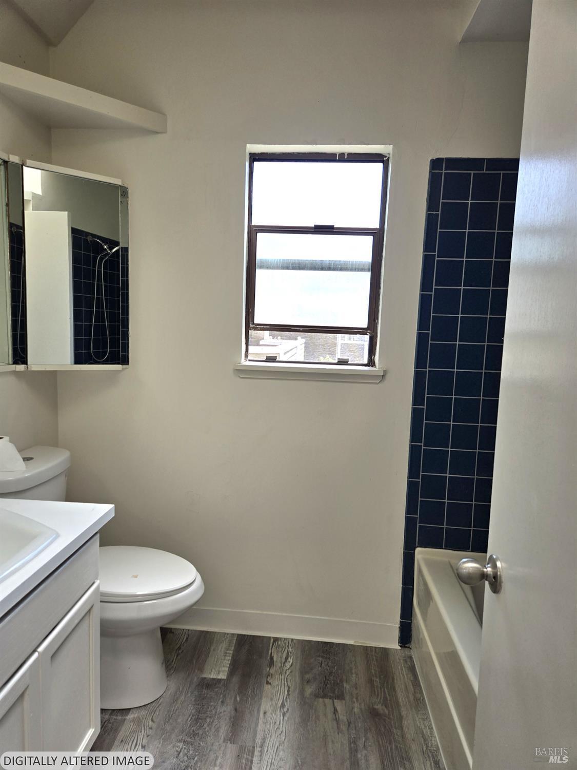 2125 West Steele Lane Santa Rosa, CA 95403 - Photo 11 of 16 a white toilet sitting next to a bathroom sink and tub
