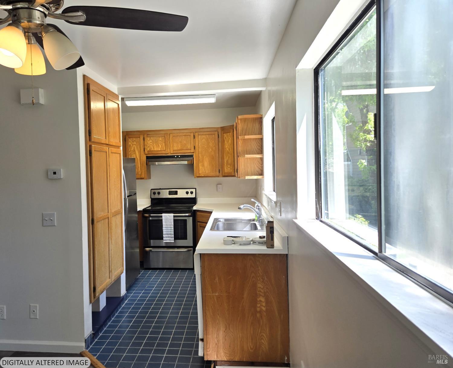 2125 West Steele Lane Santa Rosa, CA 95403 - Photo 4 of 16 a kitchen with granite countertop a stove and a refrigerator