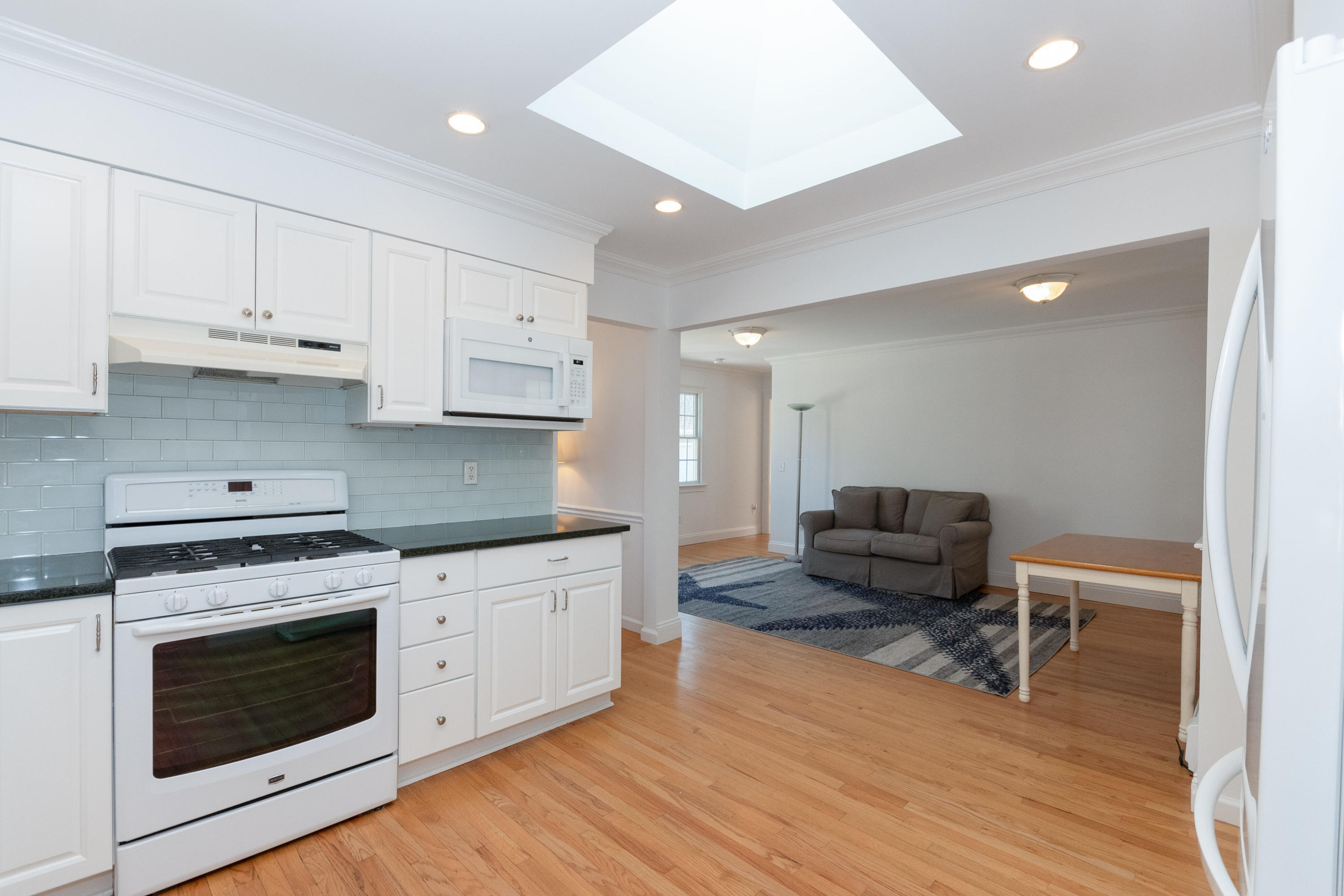 11 Cottontail Road Norwalk, CT 06854 - Photo 15 of 51 a kitchen with stainless steel appliances granite countertop a stove top oven a sink dishwasher and a refrigerator with wooden floor