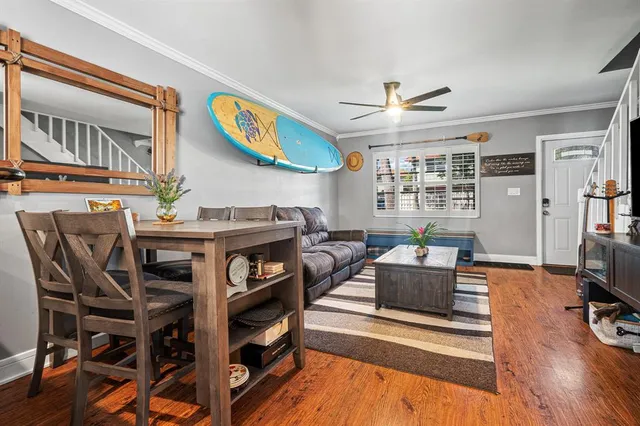 a living room with furniture a rug and a ceiling fan