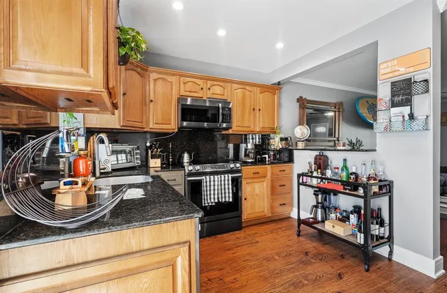 a kitchen with stainless steel appliances granite countertop a sink stove and cabinets