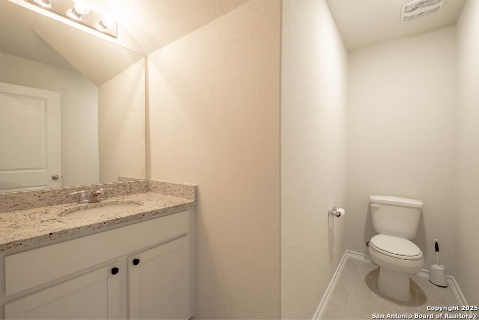 3934 Copper River Bulverde, TX 78163 - Photo 11 of 28 a bathroom with a granite countertop toilet and a sink