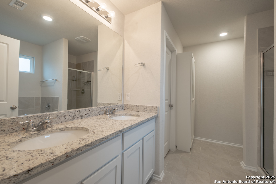 3934 Copper River Bulverde, TX 78163 - Photo 18 of 28 a bathroom with a granite countertop sink and a mirror
