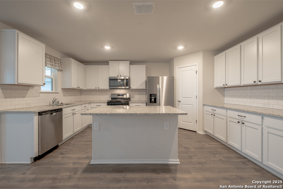 3934 Copper River Bulverde, TX 78163 - Photo 7 of 28 a kitchen with stainless steel appliances granite countertop a sink a stove a refrigerator and cabinets