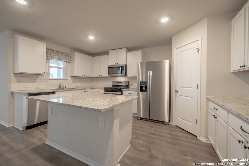 3934 Copper River Bulverde, TX 78163 - Photo 8 of 28 a kitchen with stainless steel appliances granite countertop a refrigerator sink and white cabinets