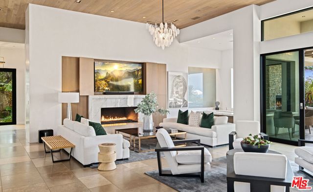 a living room with furniture fireplace and large windows
