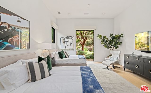 a spacious bedroom with a bed and a potted plant