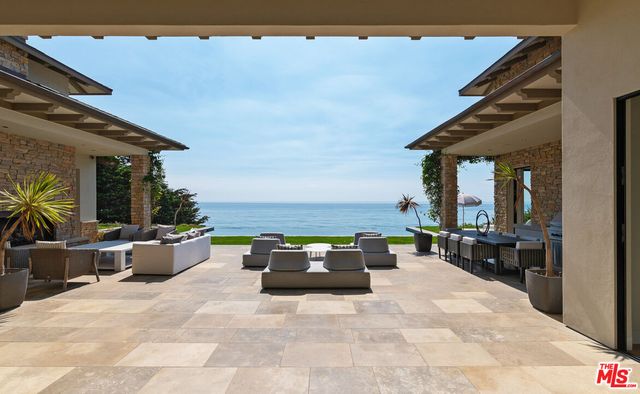 a view of a patio with a dining table and chairs with wooden floor
