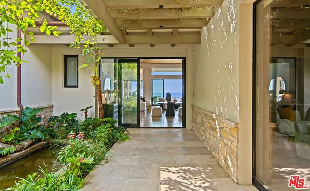 a living room with furniture a chandelier and a large window