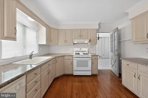 a kitchen with granite countertop white cabinets and white appliances