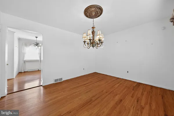 a view of a room with wooden floor and chandelier