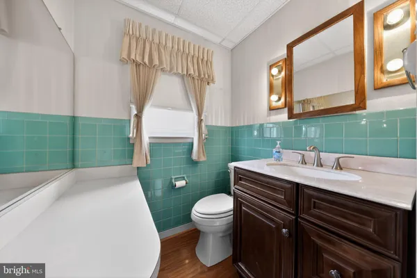 a bathroom with a sink toilet and mirror