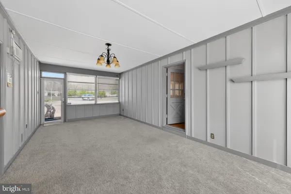 an empty room with windows and ceiling fan