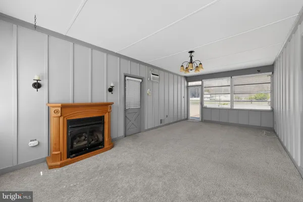 a view of an empty room with a fireplace and a window