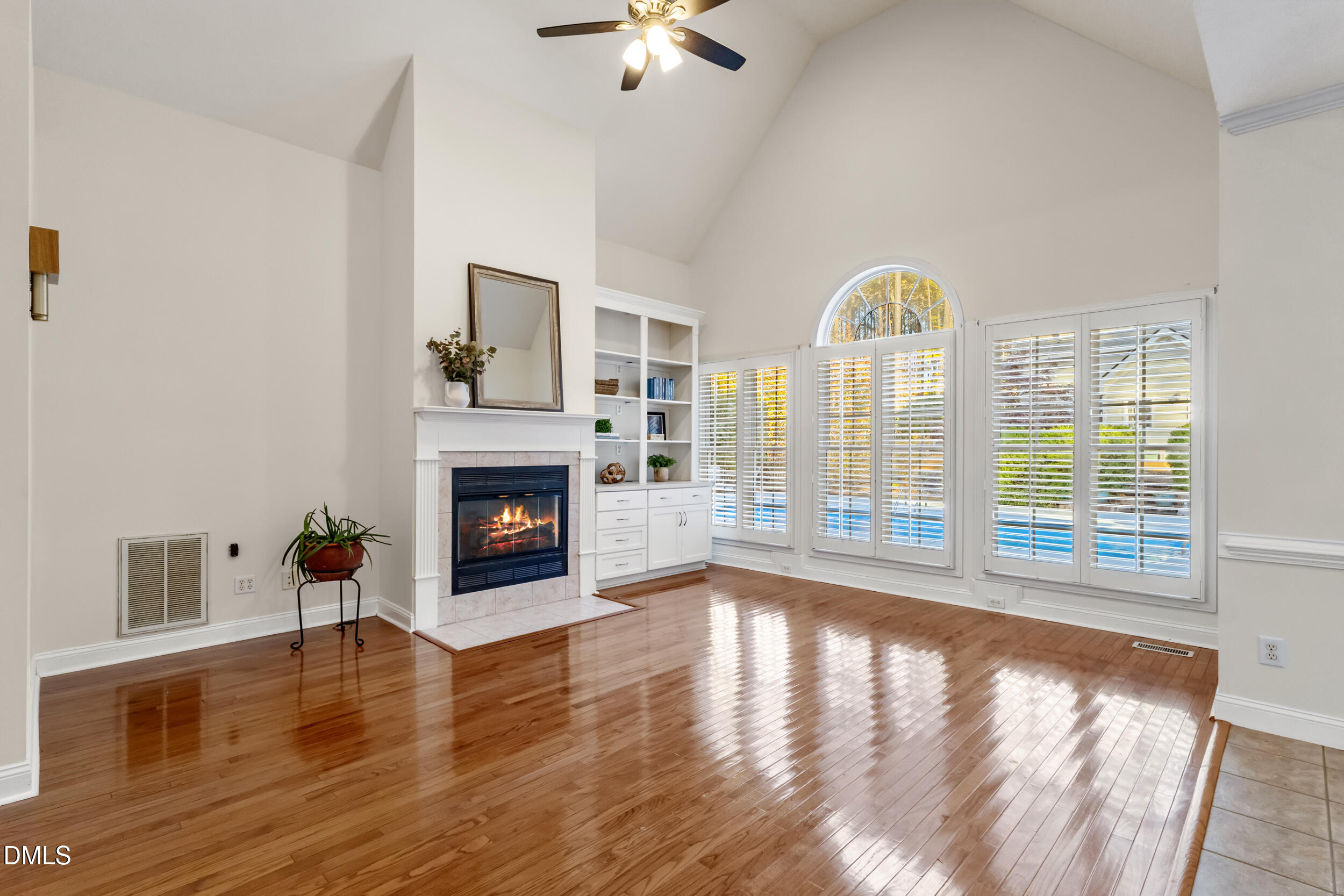 6816 Cool Pond Road Raleigh, NC 27613 - Photo 10 of 65 a view of an empty room with wooden floor fireplace and a window
