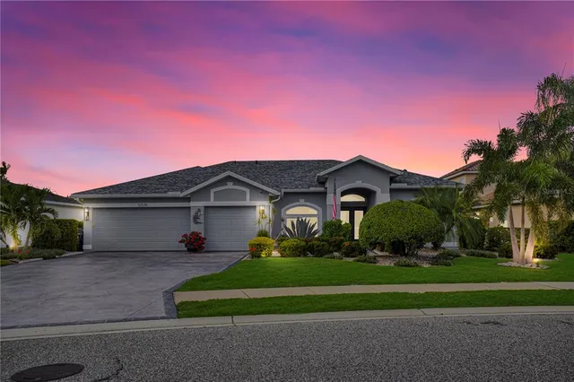 a front view of a house with a yard and potted plants