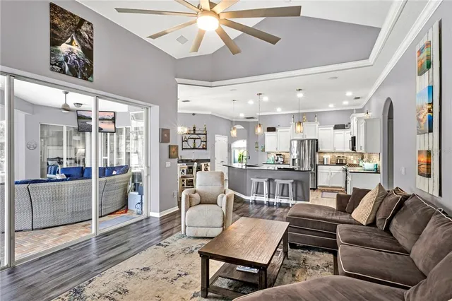 a living room with furniture and a view of kitchen