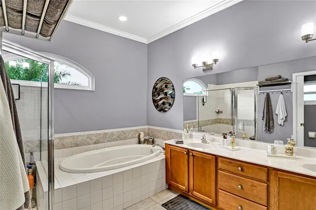 a bathroom with a tub a double vanity sink and a mirror