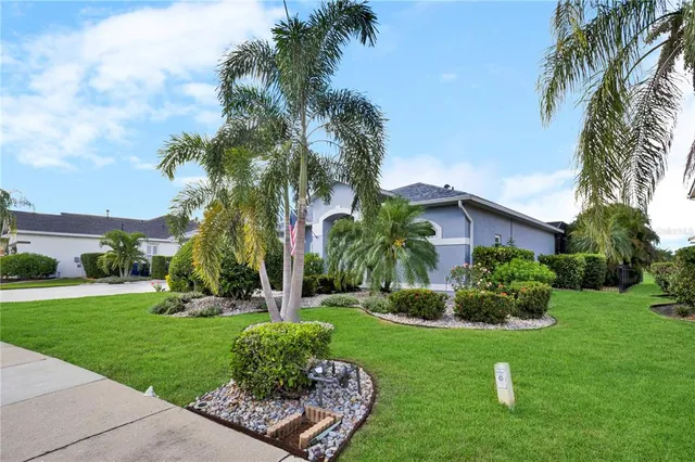 a front view of a house with a yard and potted plants