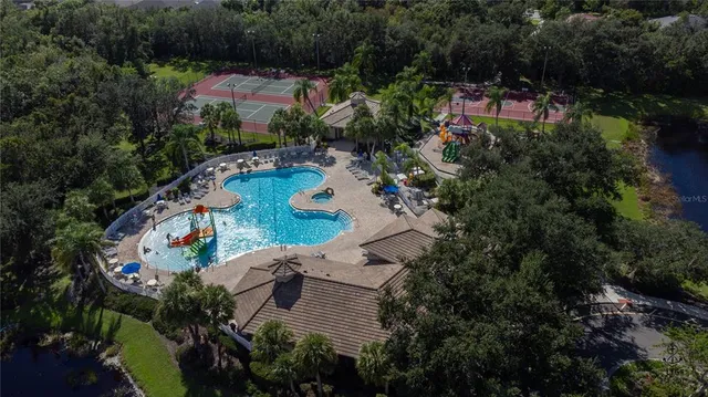 an aerial view of a house with a yard and lake view