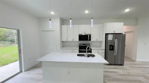 a kitchen with a refrigerator a stove top oven and a refrigerator