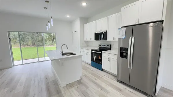 a kitchen with a refrigerator a sink and a stove top oven