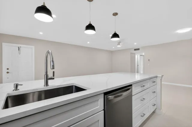 a kitchen with a sink and chandelier