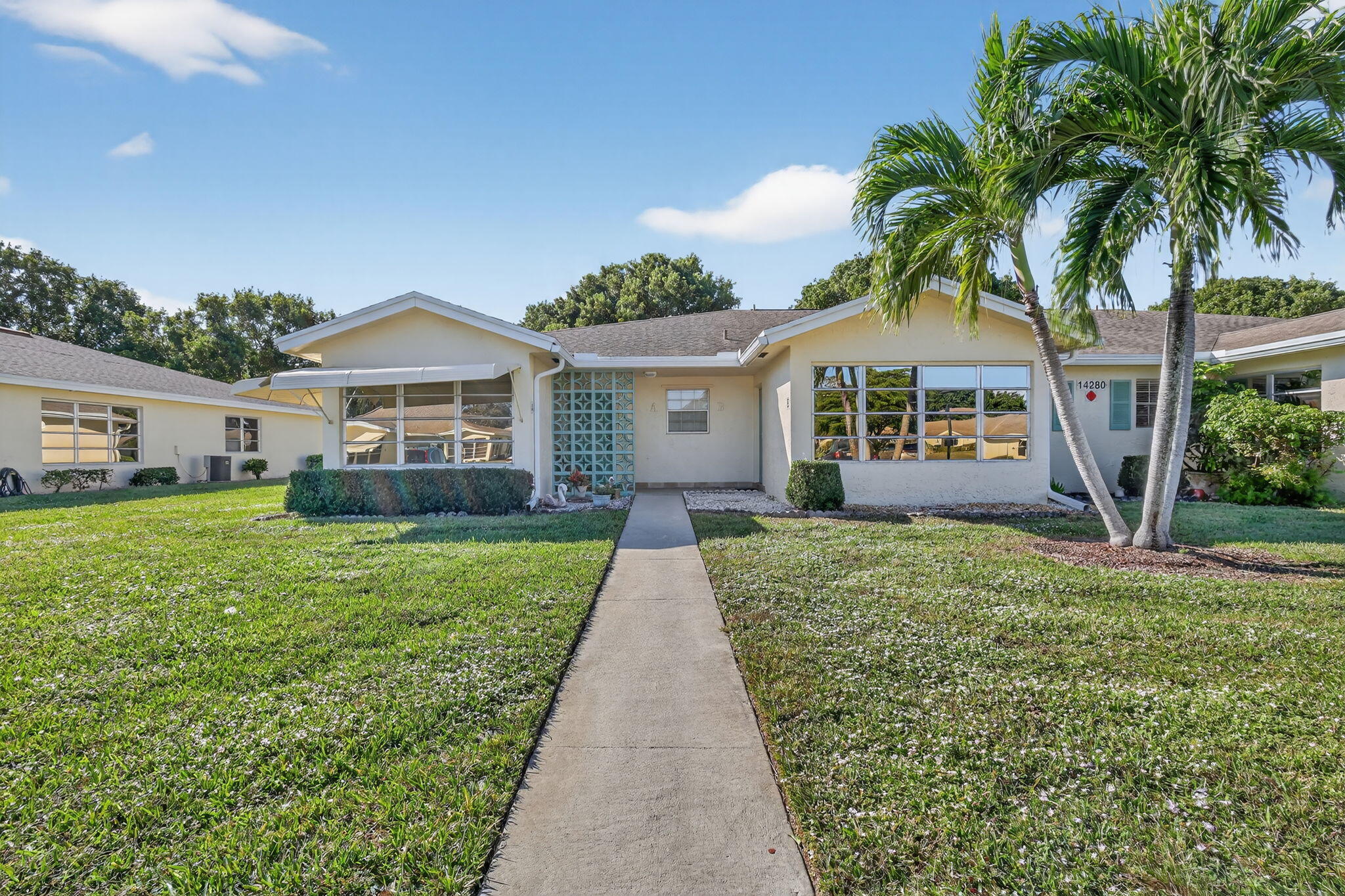 14280 Nesting Way, Unit B Delray Beach, FL 33484 - Photo 28 of 43 a front view of a house with a garden and yard