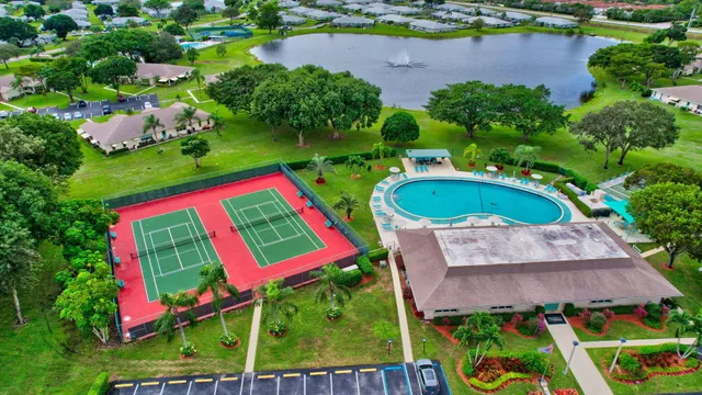 a view of a swimming pool with lawn chairs under an umbrella
