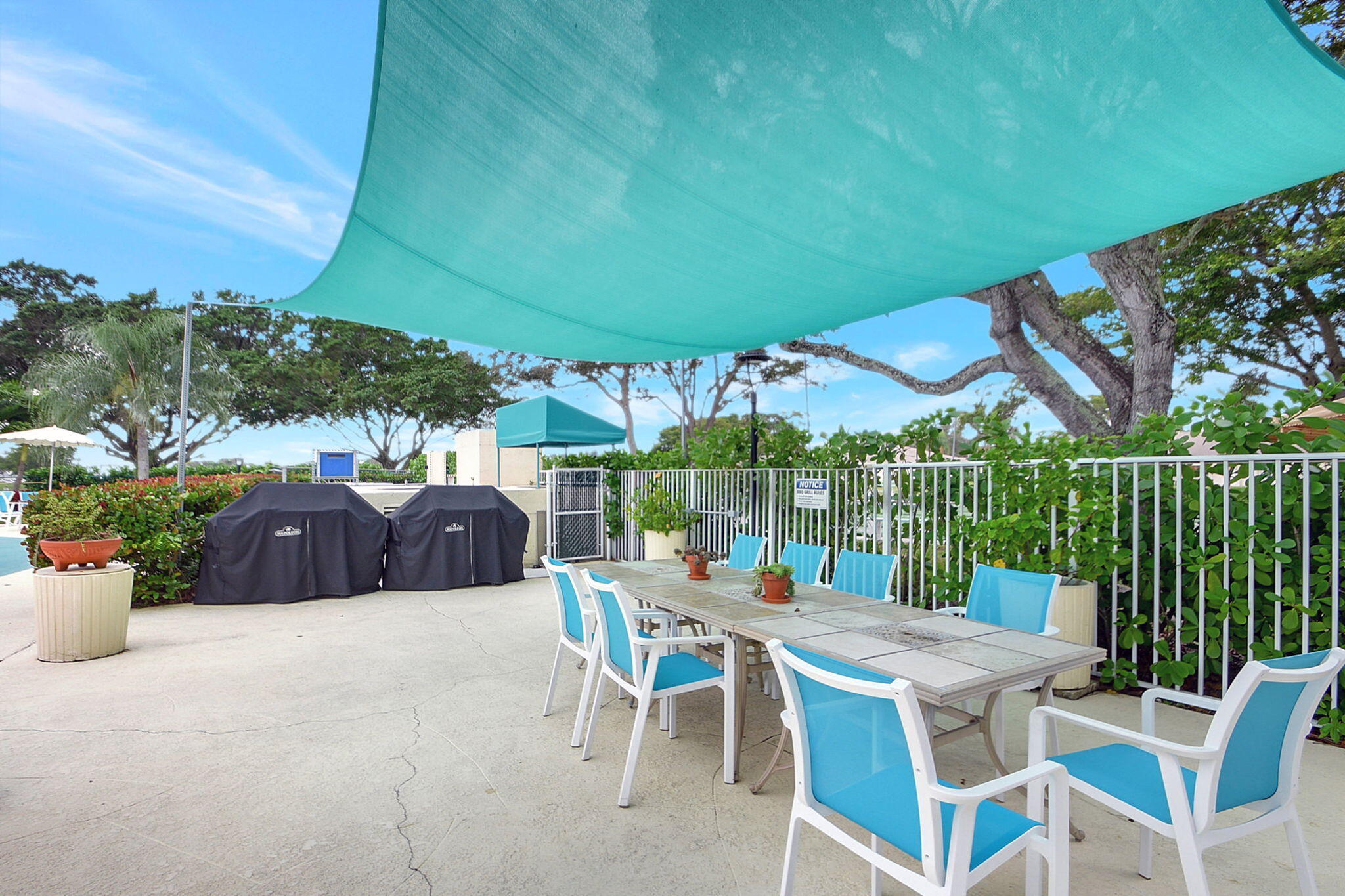 14280 Nesting Way, Unit B Delray Beach, FL 33484 - Photo 36 of 43 a view of a patio with a table and chairs under an umbrella